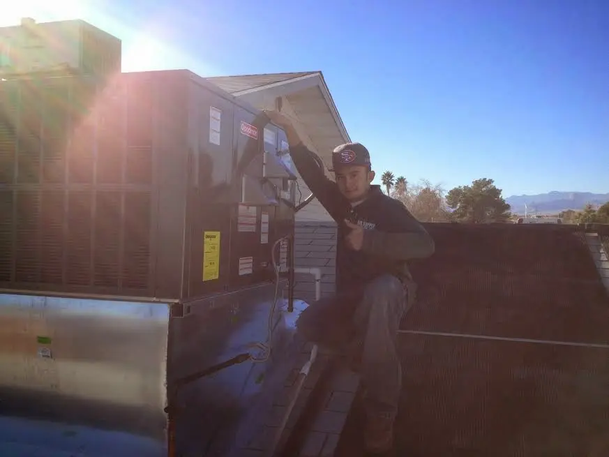 HVAC technician performing AC Tune-Up on a rooftop unit in North Caldwell